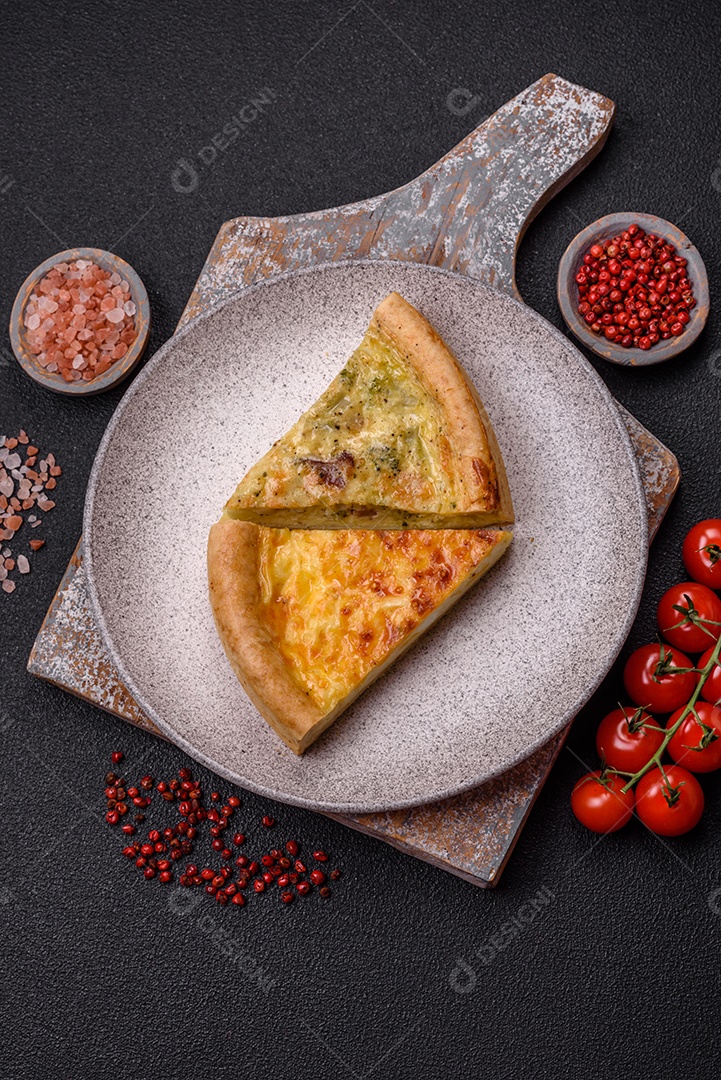 Deliciosa quiche com brócolis, frango ou salmão e queijo com sal e especiarias sobre fundo escuro de concreto