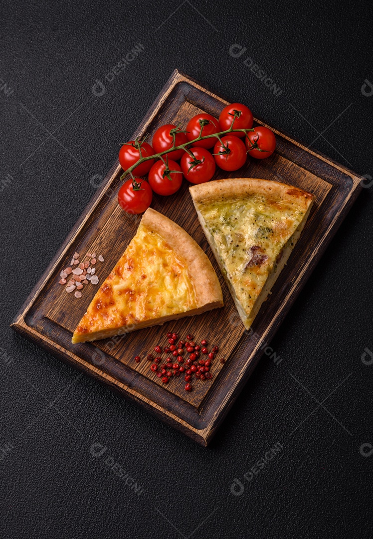 Deliciosa quiche com brócolis, frango ou salmão e queijo com sal e especiarias sobre fundo escuro de concreto