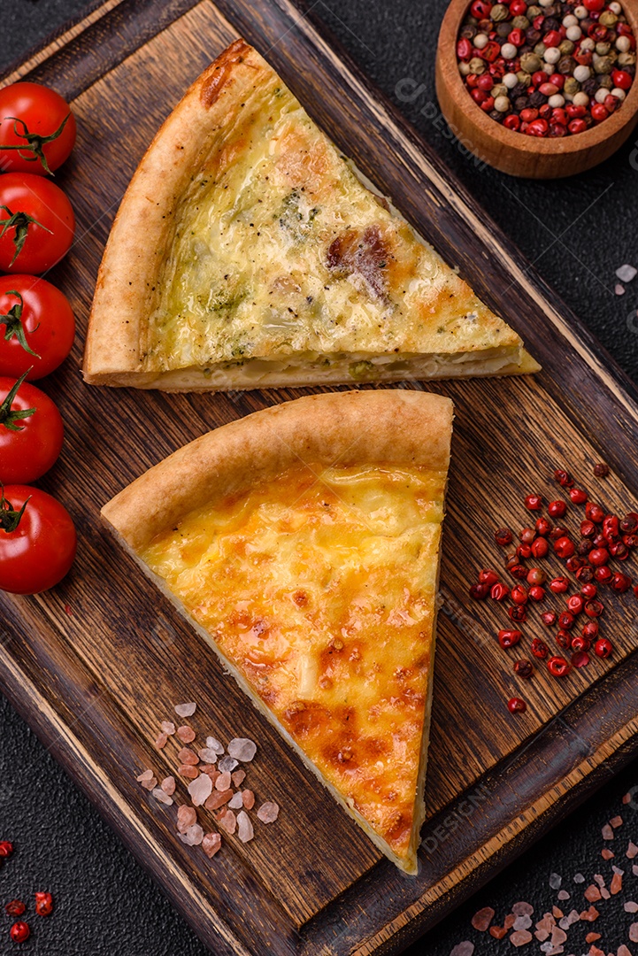 Deliciosa quiche com brócolis, frango ou salmão e queijo com sal e especiarias sobre fundo escuro de concreto