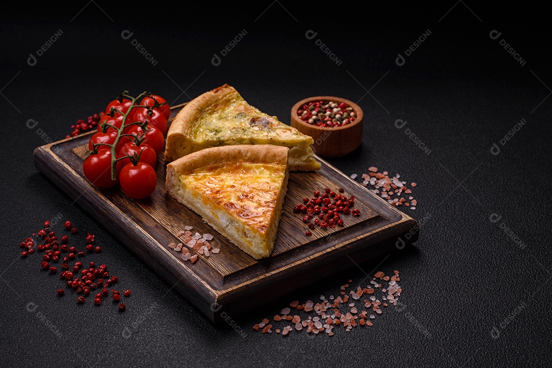 Deliciosa quiche com brócolis, frango ou salmão e queijo com sal e especiarias sobre fundo escuro de concreto