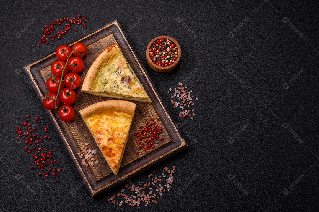 Deliciosa quiche com brócolis, frango ou salmão e queijo com sal e especiarias sobre fundo escuro de concreto