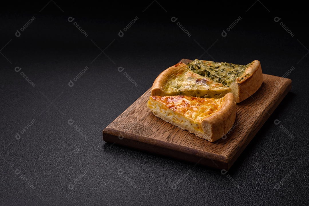 Deliciosa quiche com brócolis, frango ou salmão e queijo com sal e especiarias sobre fundo escuro de concreto