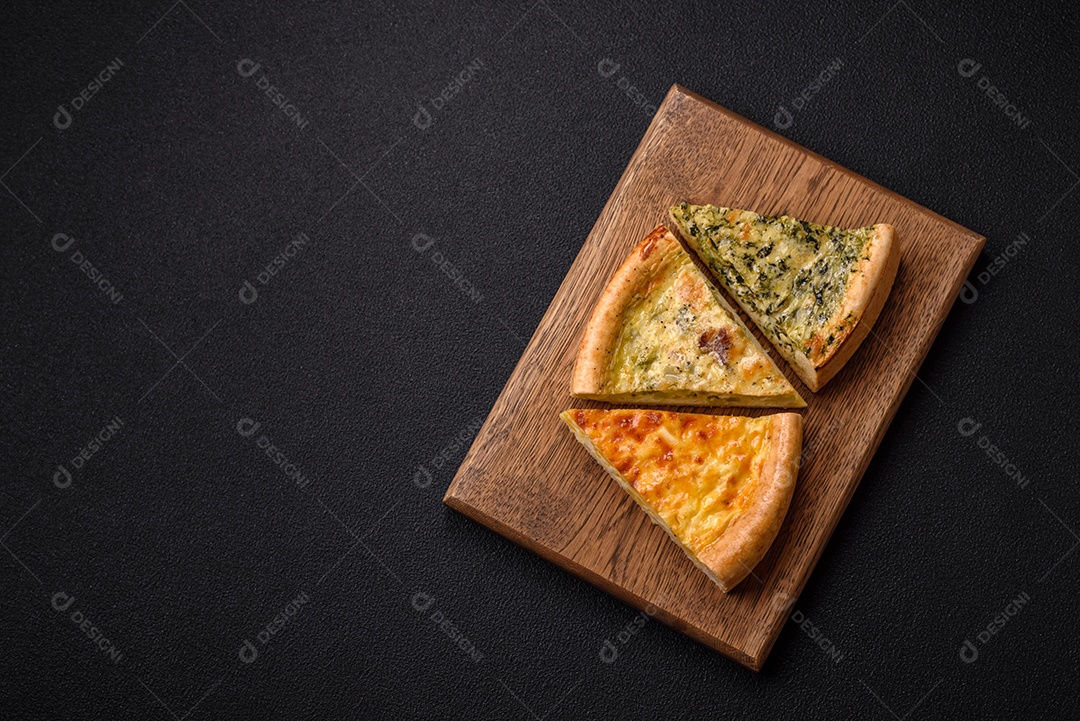 Deliciosa quiche com brócolis, frango ou salmão e queijo com sal e especiarias sobre fundo escuro de concreto