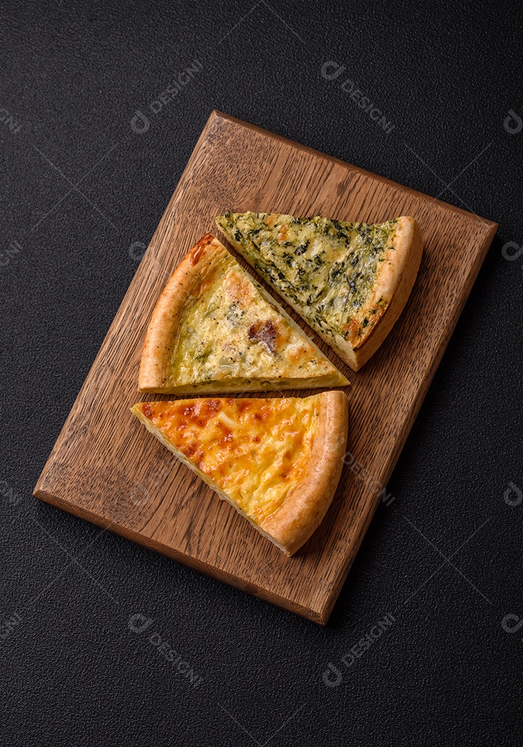 Deliciosa quiche com brócolis, frango ou salmão e queijo com sal e especiarias sobre fundo escuro de concreto