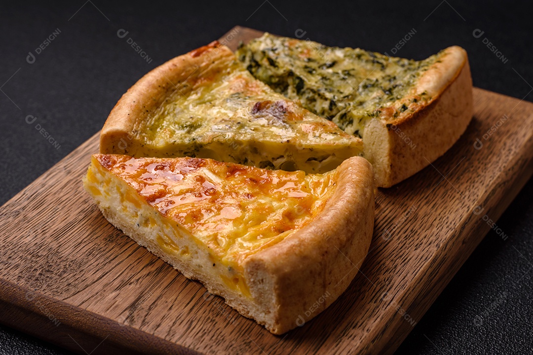 Deliciosa quiche com brócolis, frango ou salmão e queijo com sal e especiarias sobre fundo escuro de concreto