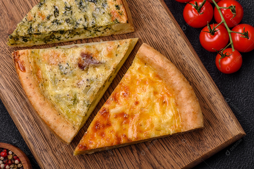 Deliciosa quiche com brócolis, frango ou salmão e queijo com sal e especiarias sobre fundo escuro de concreto