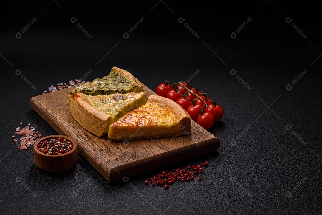 Deliciosa quiche com brócolis, frango ou salmão e queijo com sal e especiarias sobre fundo escuro de concreto