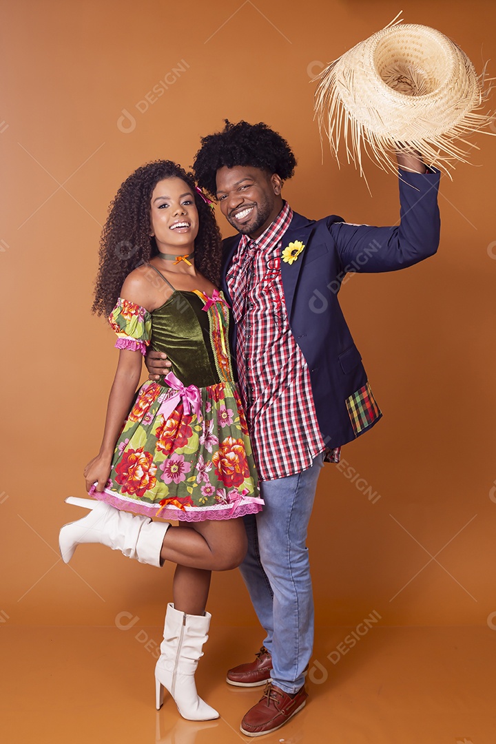 Casal sorrindo trajado para festa junina