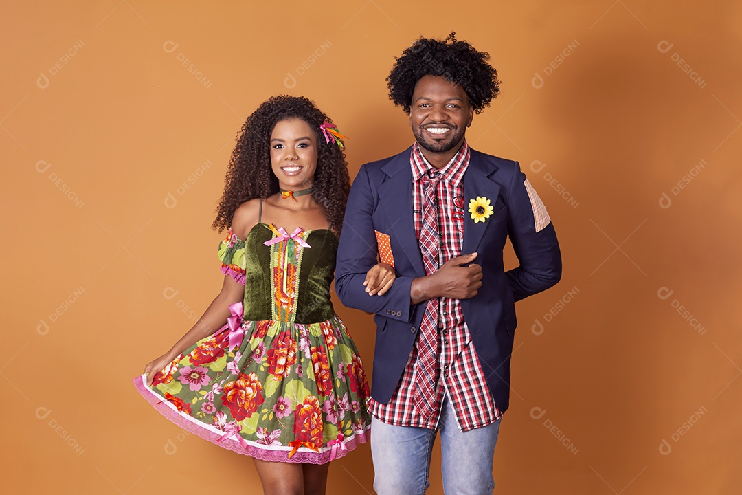 Casal trajado para festa junina sobre fundo alaranjado