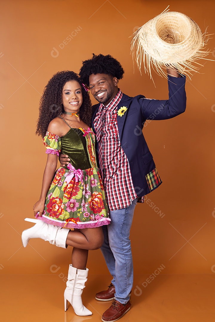 Casal trajado para festa junina sobree fundo alaranjado