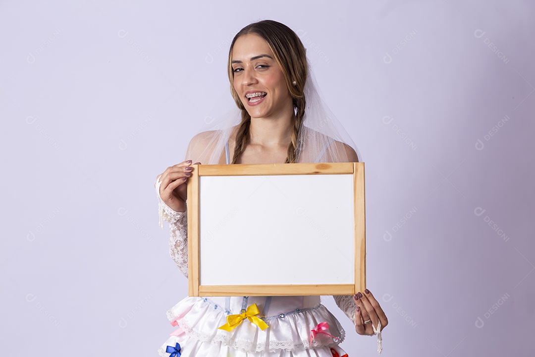 Jovem de noiva para festa junina segurando quadro