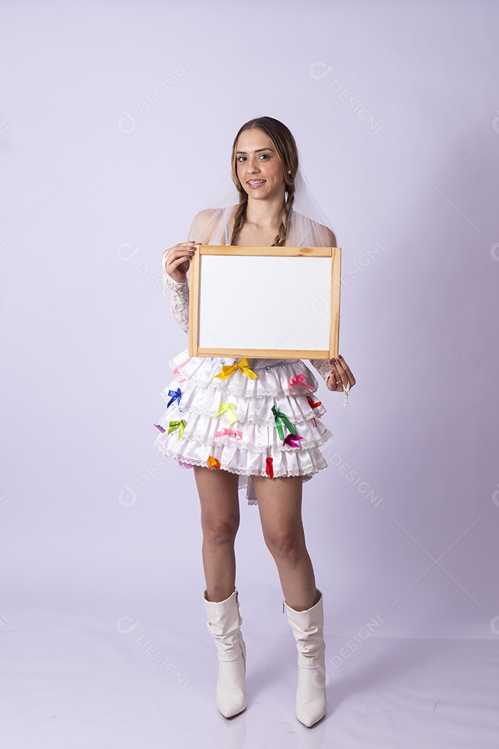 Jovem de noiva para festa junina segurando quadro
