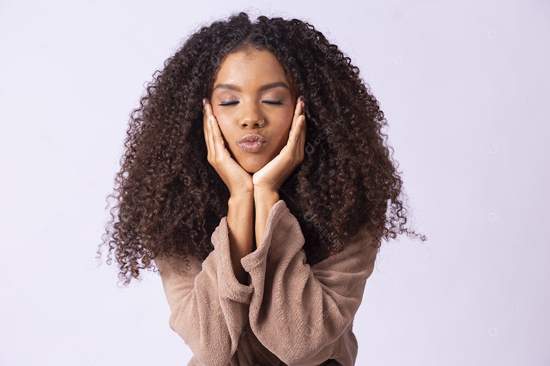 Jovem morena de cabelos cacheados fazendo pose para foto