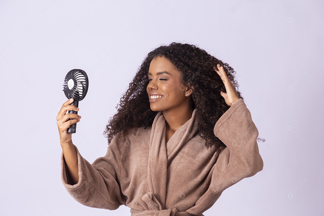 Jovem negra com mini ventilador sobre seu rosto