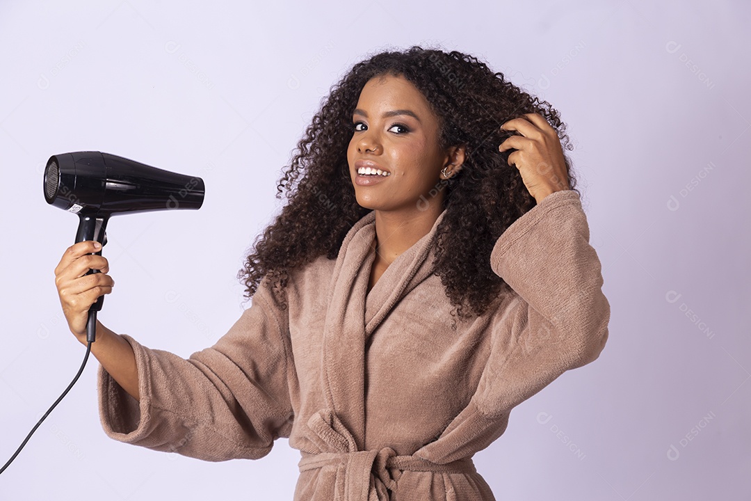 Mulher negra bonita secando seus cabelos com secador