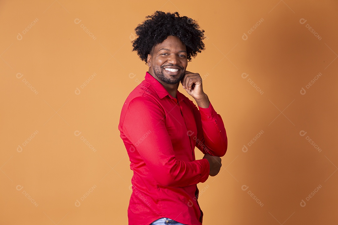 Homem moreno sorrindo com a mão no rosto