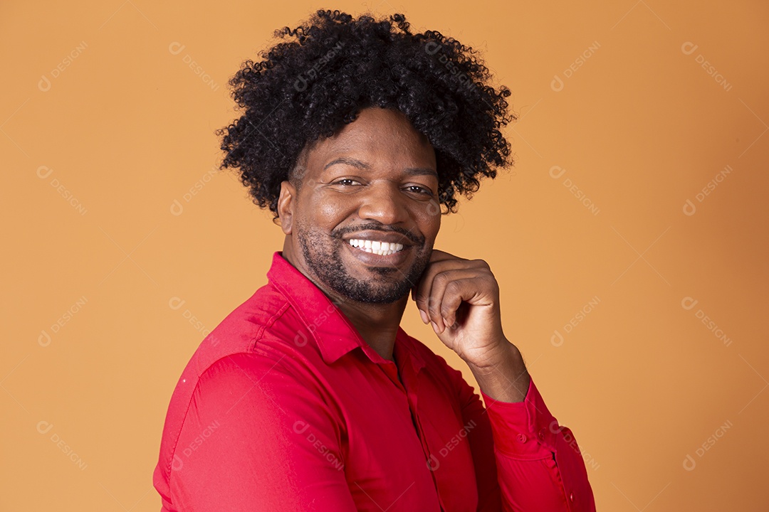 Homem moreno sorrindo com mão no queixo