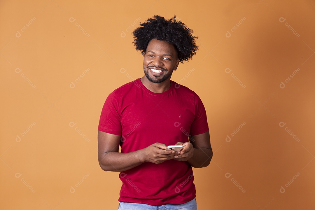 Homem sorrindo e segurando celular na mãos