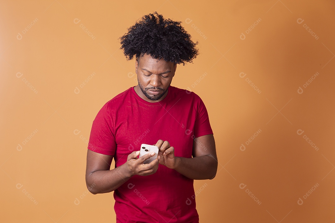 Homem de camiseta de vermelha segurando celular e mexendo