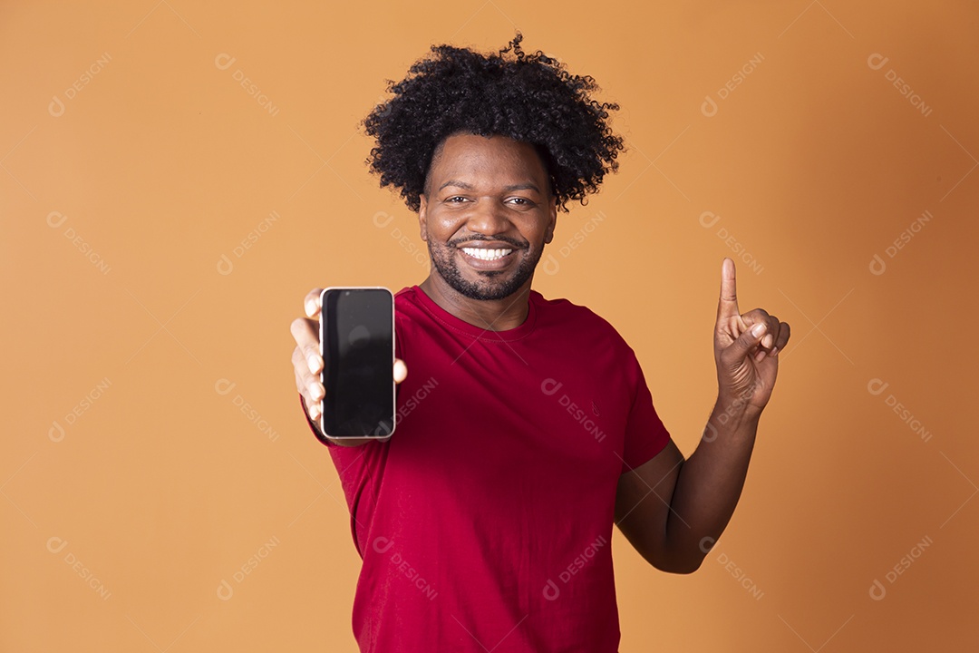 Homem de camiseta de vermelha segurando celular e apontando para cima