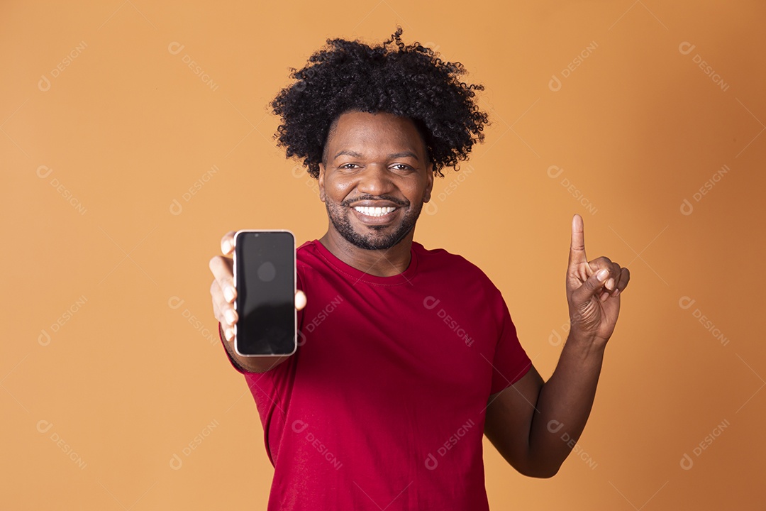 Homem de camiseta de vermelha segurando celular e apontando para cima