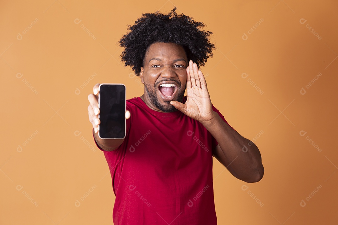 Homem com camiseta vermelha gritando com celular nas mão