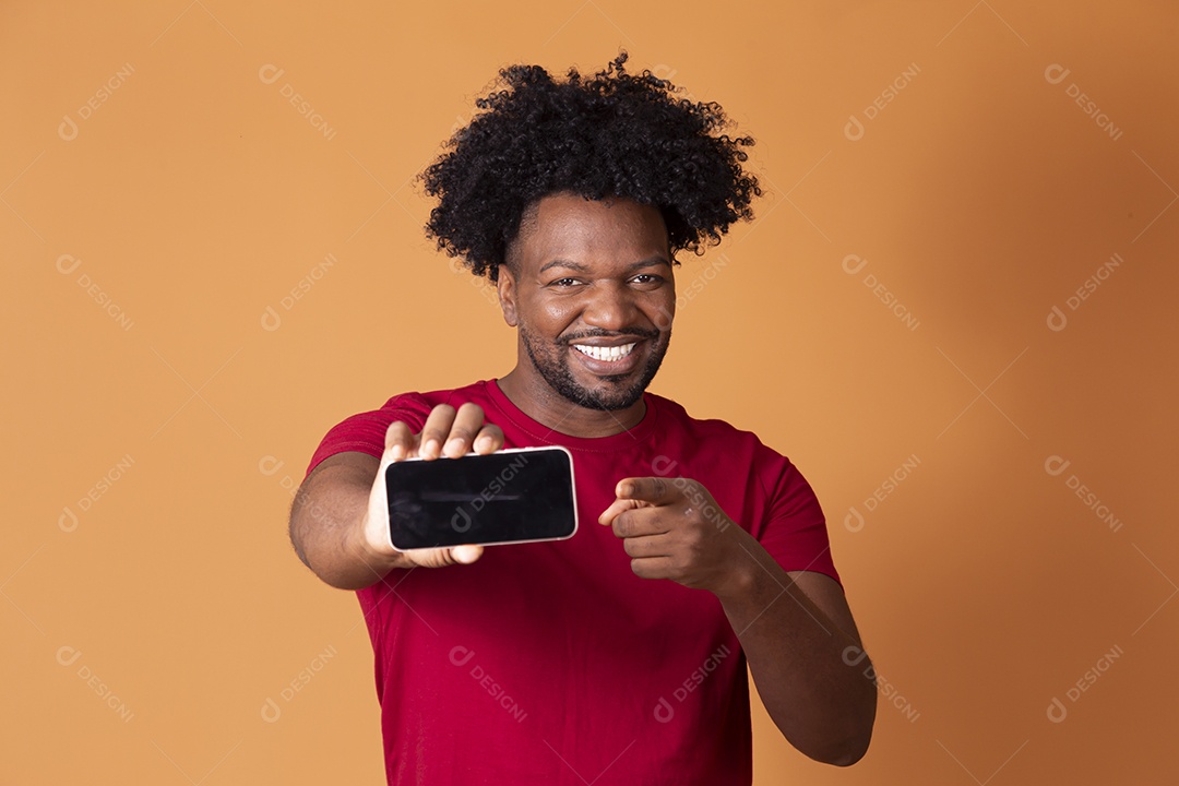Homem de camiseta de vermelha segurando celular e apontando para frente