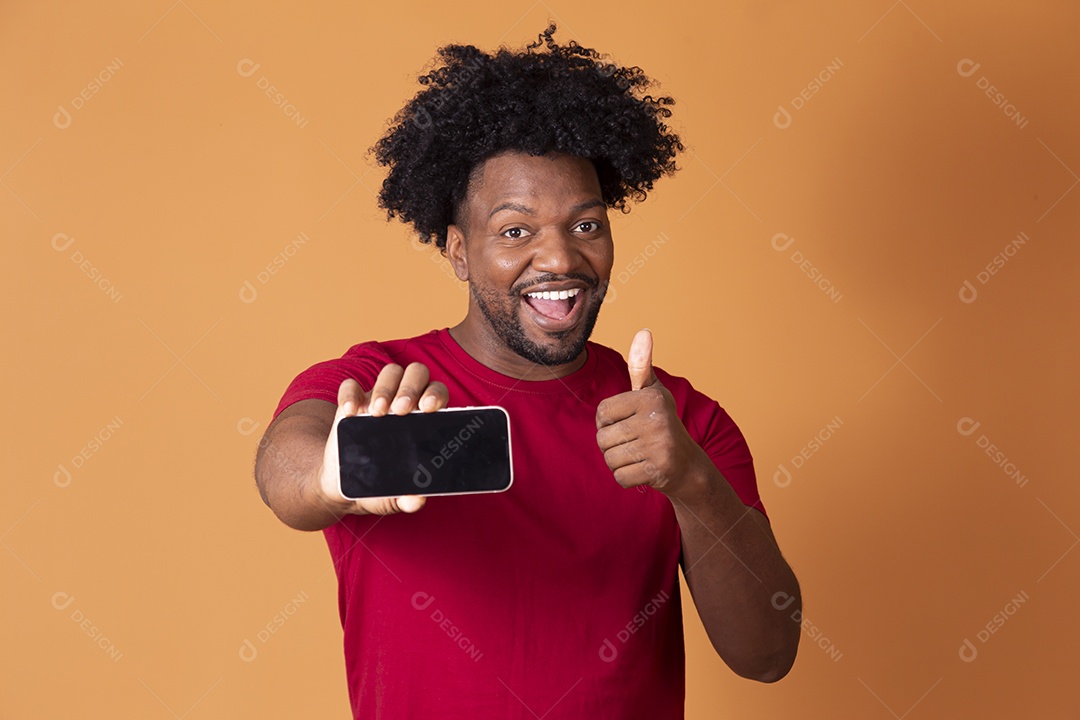 Homem moreno com celular na mão e fundo alaranjada