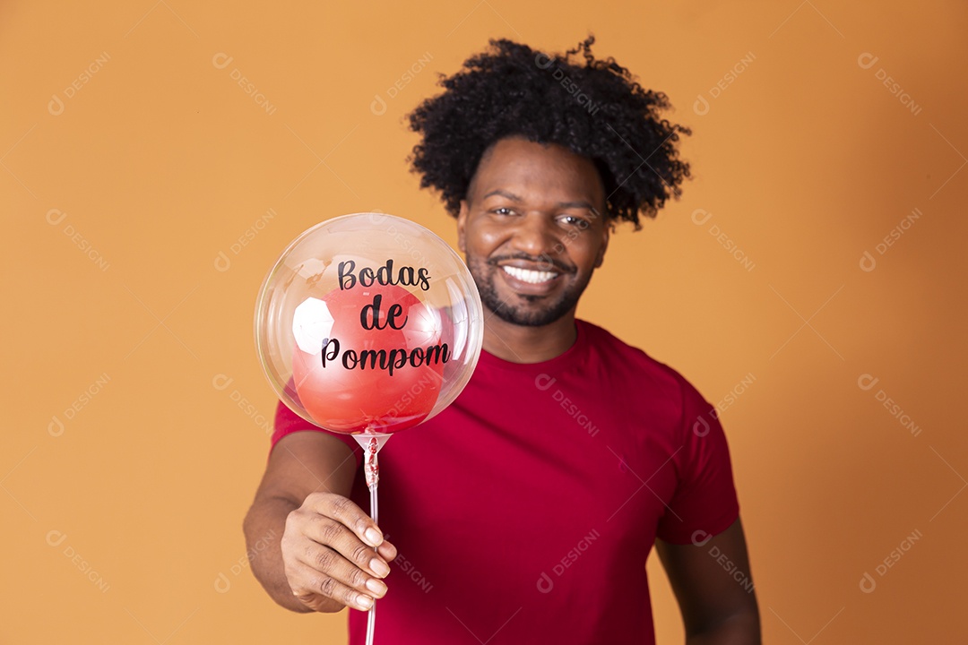 Homem de camiseta vermelha segurando balão oitavo mês de casado