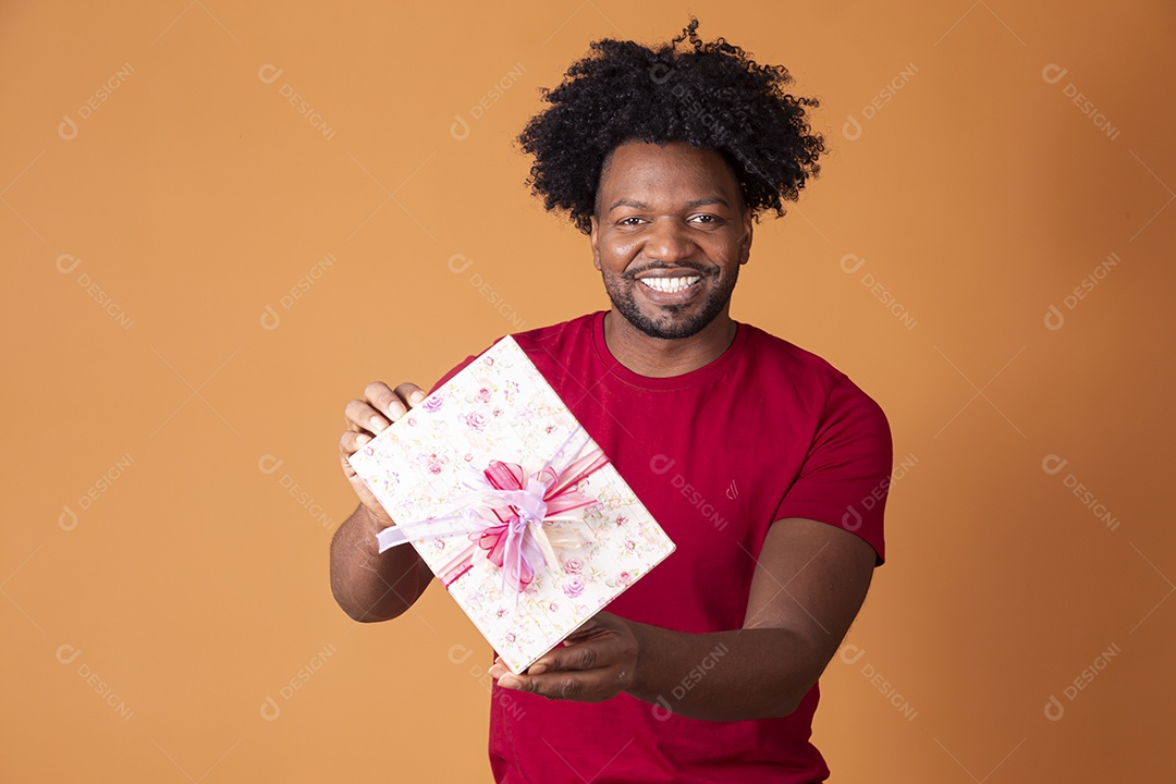 Homem moreno bonito segurando caixa de presente