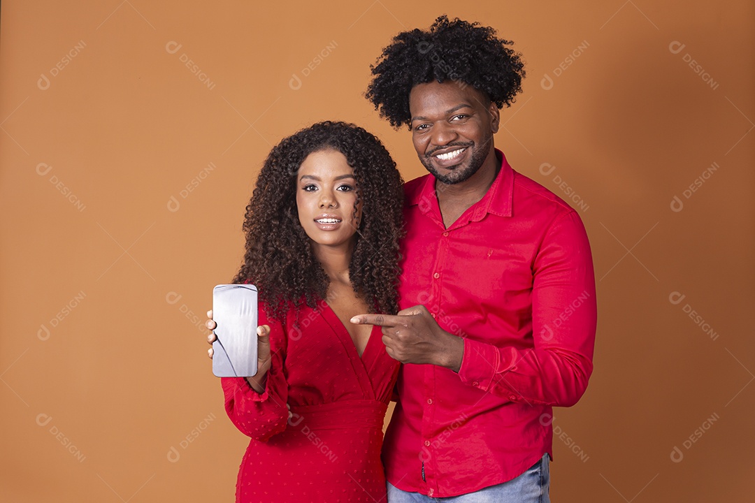 Casal feliz apontando para um novo aparelho celular