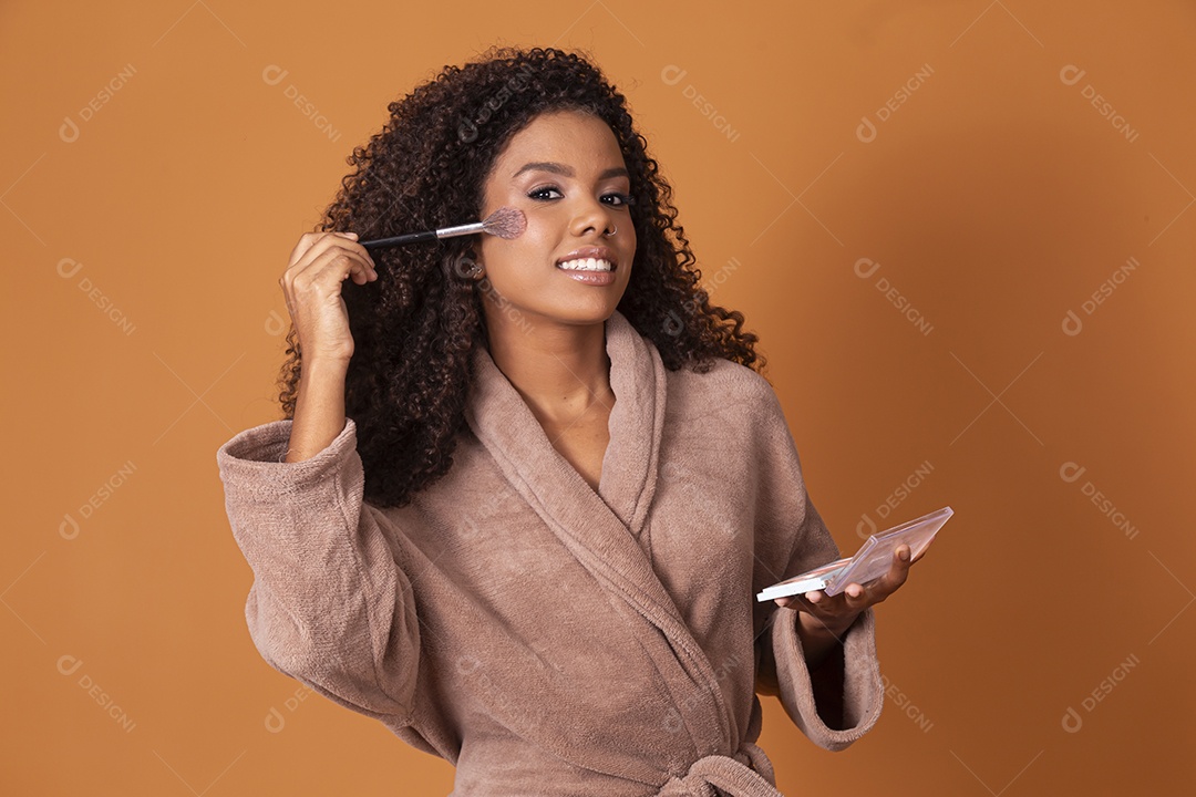 Uma jovem linda usando maquiagem sobre fundo marrom claro