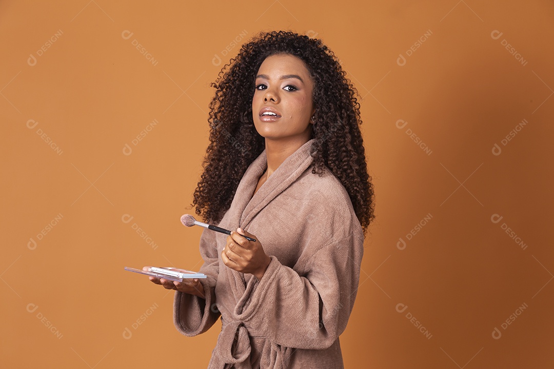 Jovem linda cacheada usando maquiagem