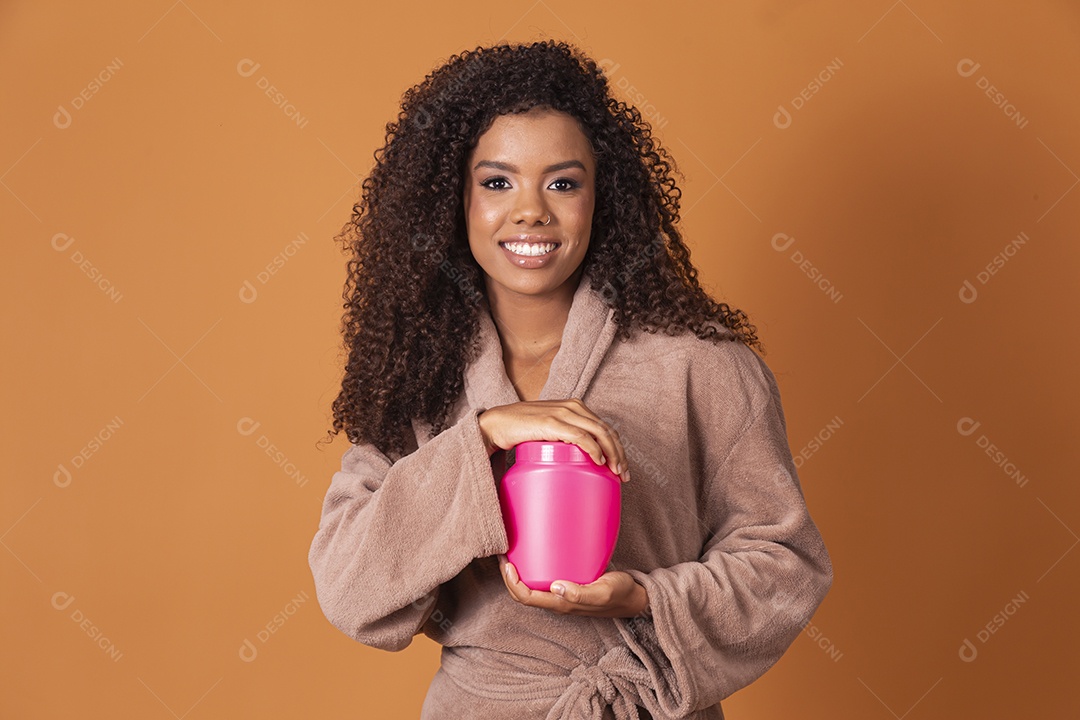 Mulher sorrindo segurando pote de creme nas mão