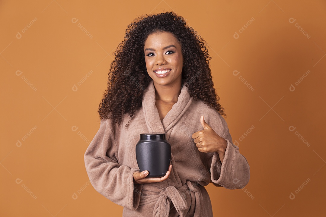 Jovem morena linda com pote de creme para cabelos cacheado