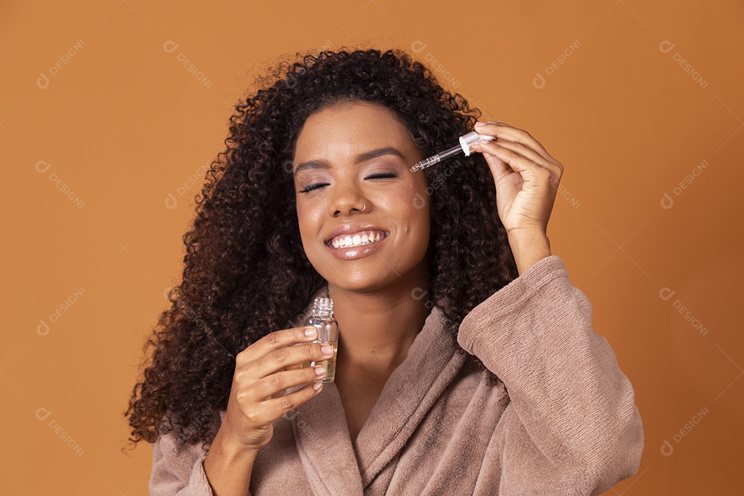 Jovem morena de cabelos cacheados cuidando de seu rosto