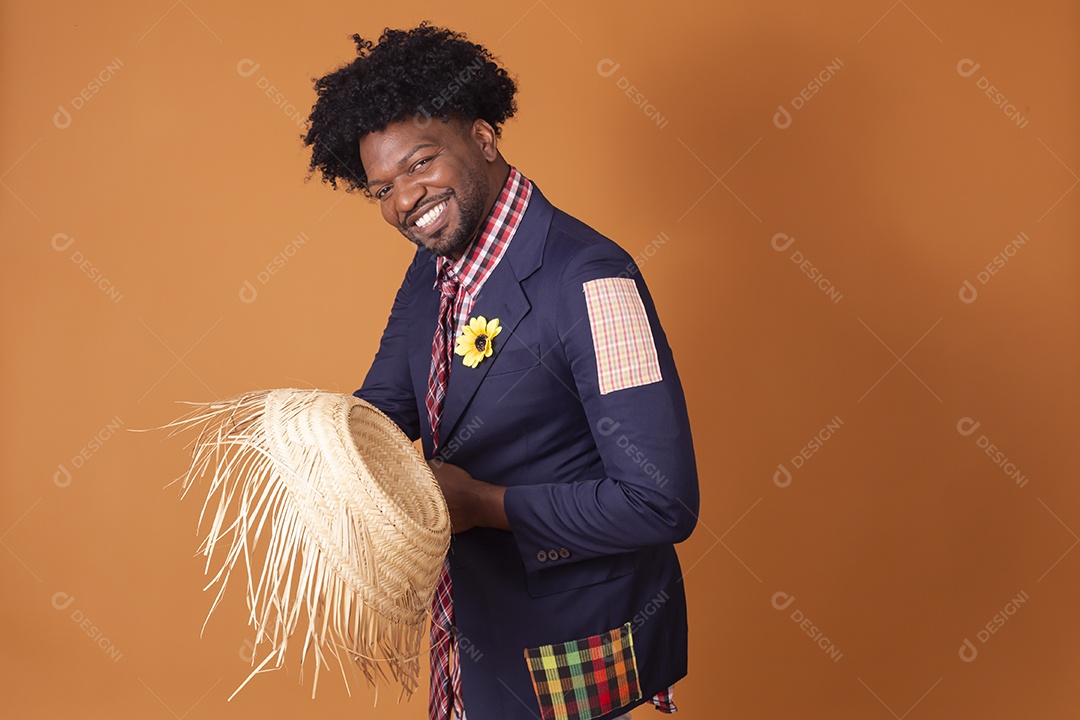 Homem sorrindo trajado para festa junina com chapéu de palha