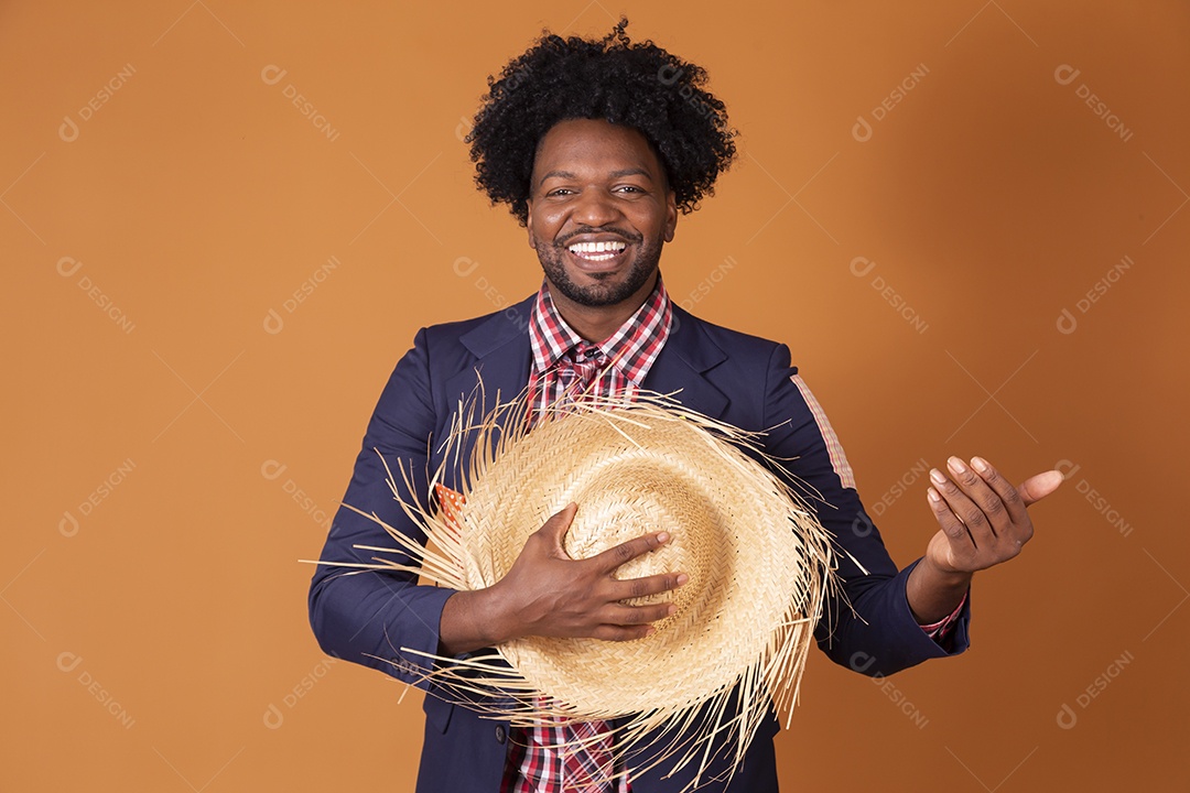 Homem trajado para festa junina com chapéu nas mãos