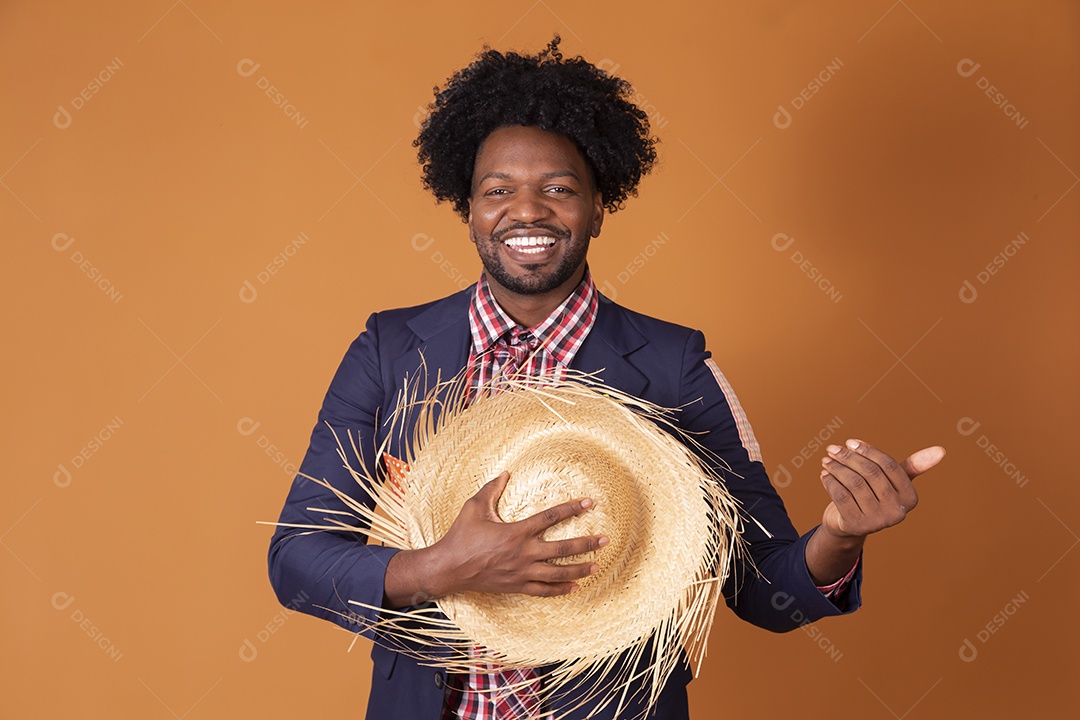 Homem sorrindo com chapéu de palha nas mãos