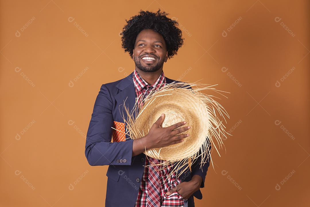 Homem trajado para festa junina com chapéu nas mãos