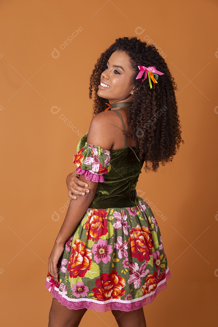 Jovem morena de cabelos cacheados fazendo pose para foto