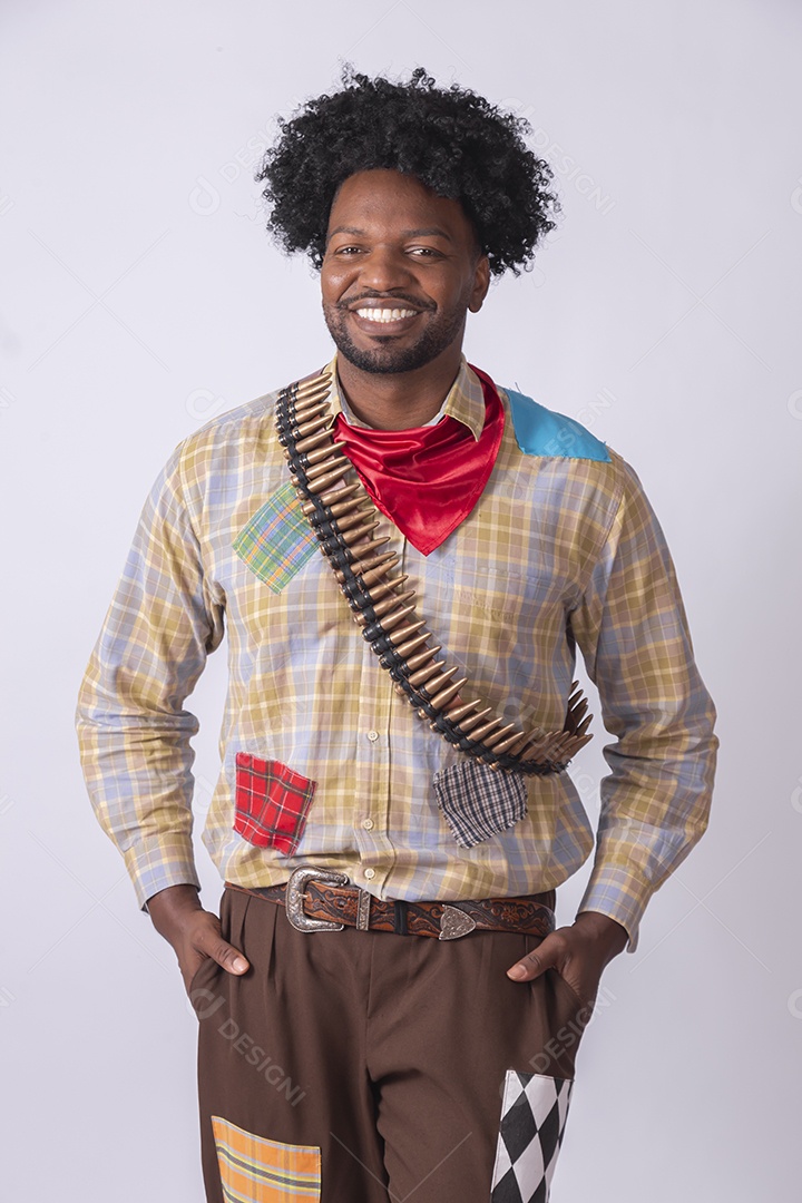 Homem sorrindo trajado para festa junina com arma na mãos