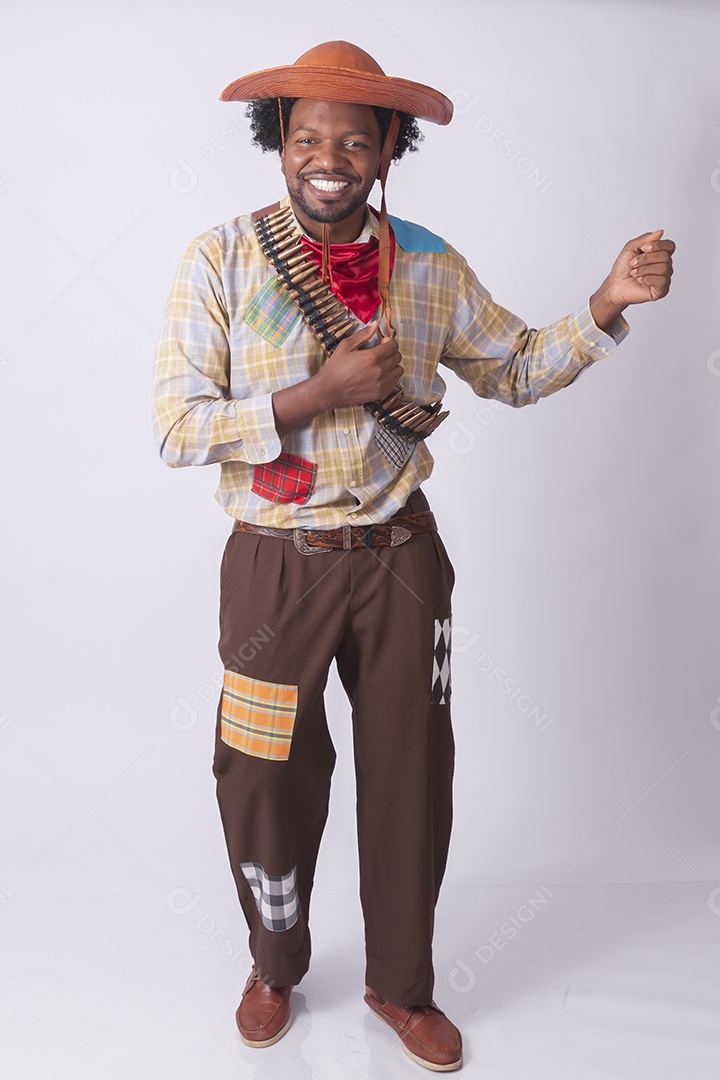 Homem vestido de lampião a caráter para festa junina apontando arma de brinquedo