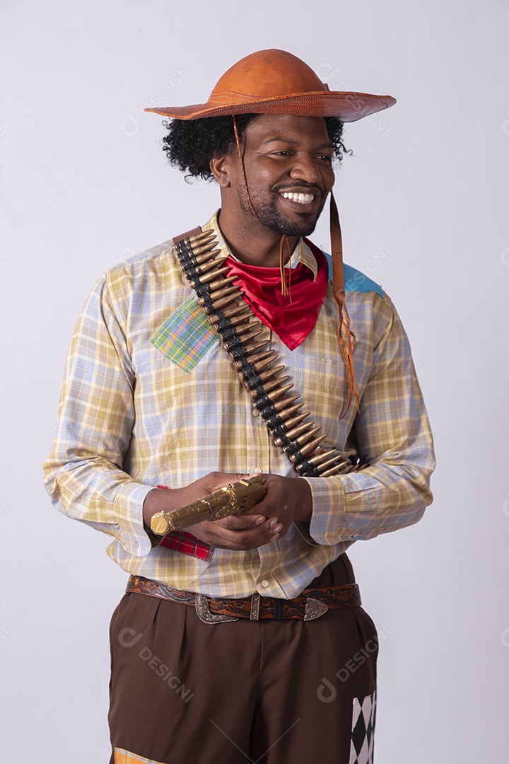 Homem vestido de lampião a caráter para festa junina apontando arma de brinquedo