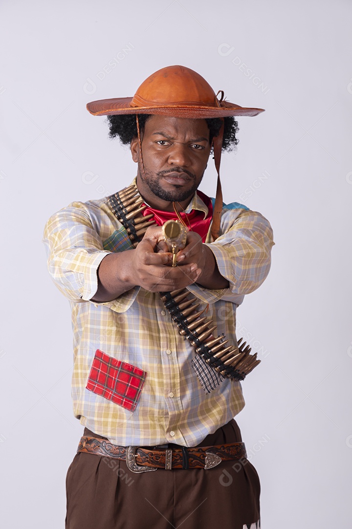 Homem vestido de lampião a caráter para festa junina apontando arma de brinquedo