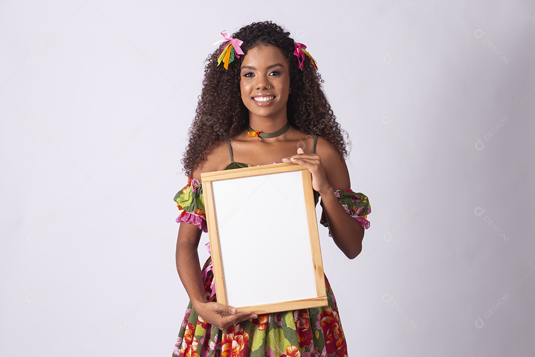 Jovem linda segurando quadro na mão com trajes juninos