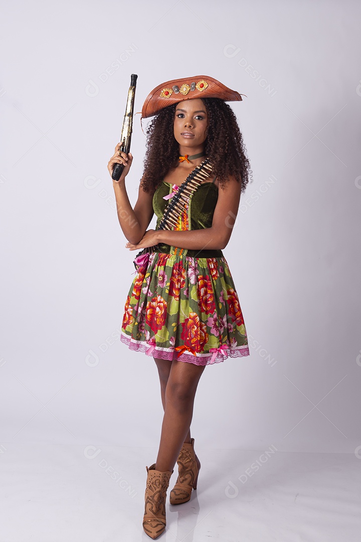 Jovem vestida de cangaceira para festa junina com arma de brinquedo na mãos