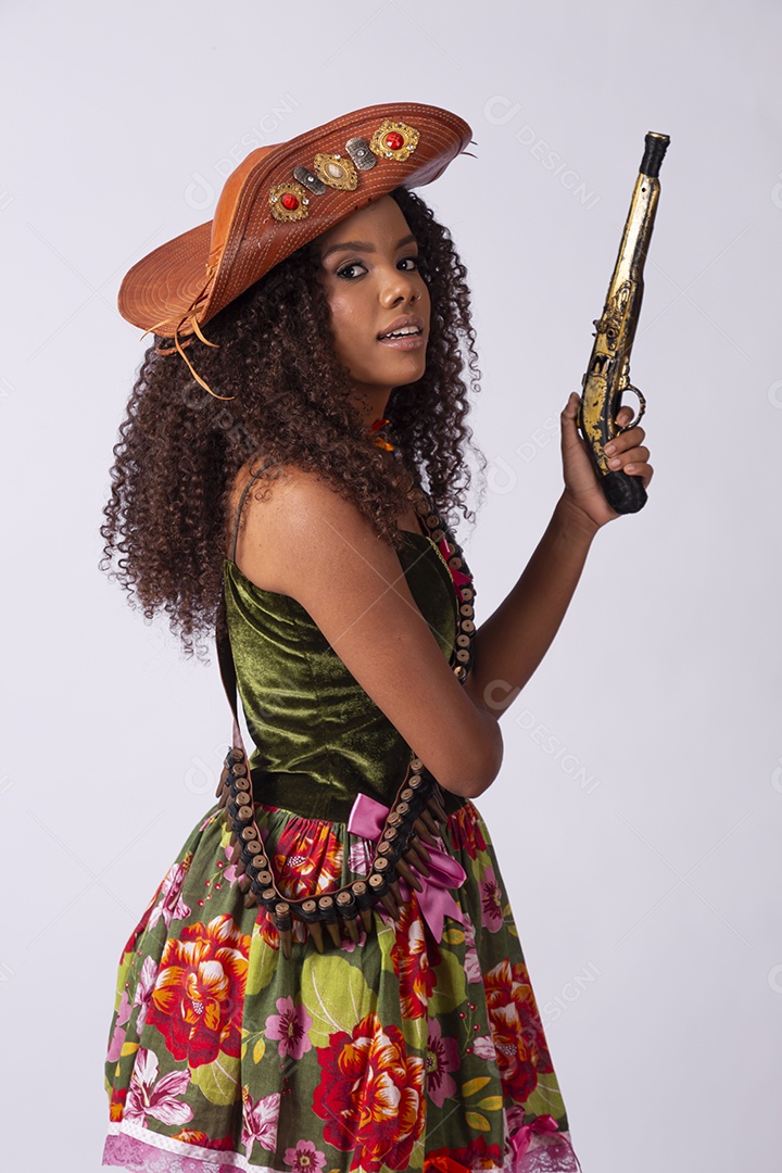 Jovem vestida a caráter para festa junina com arma de brinquedo nas mãos