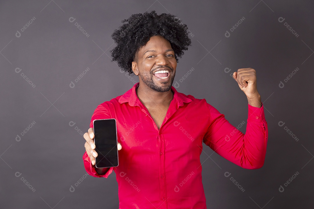 Homem comemorando algo com celular na mão