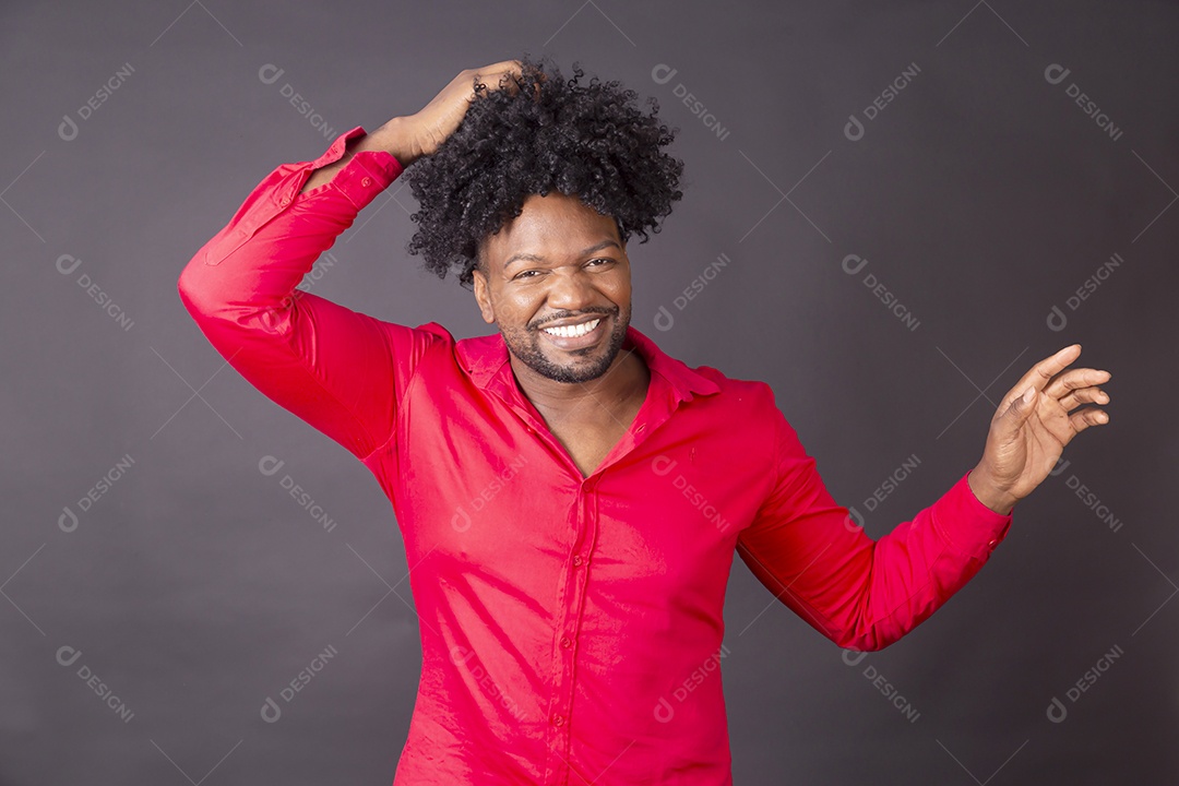 Homem moreno de vermelho com mãos no cabelos